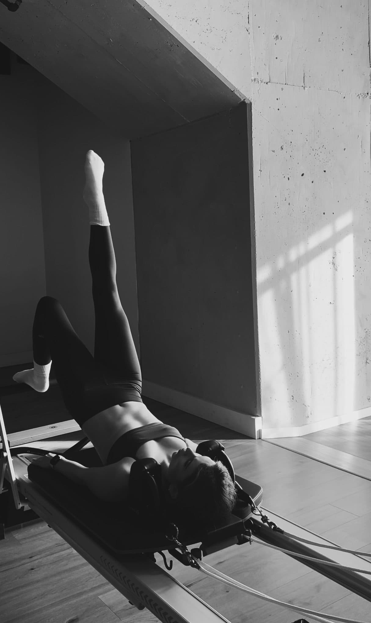 Black and white photo of a Pilates pose on the reformer at Bodies and Pilates in North Hollywood